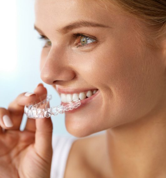 woman holding invisalign